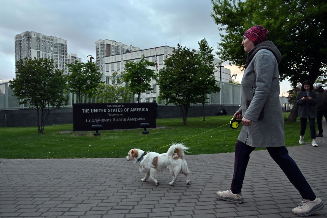 A woman walks her dog outside the US embassy in Kyiv on May 18, 2022.