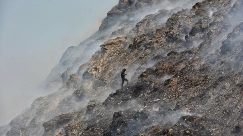 People pick up trash at the Bhalswa landfill on April 28, 2022, in New Delhi, India. 