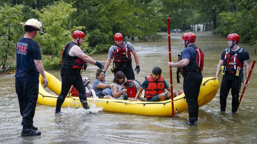 Members of the Balch Springs Fire Department bring a family of four, who did not wish to be named, by boat to higher ground after rescuing them from their home along Forest Glen Lane in Balch Springs, Texas, Monday, August 22, 2022.