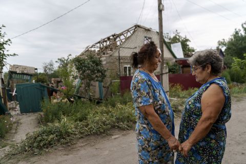 Valentyna Kondratieva, 75, left, is comforted by a neighbor as they stand outside her damaged home, in Kramatorsk, Ukraine, on August 13, after a rocket attack.