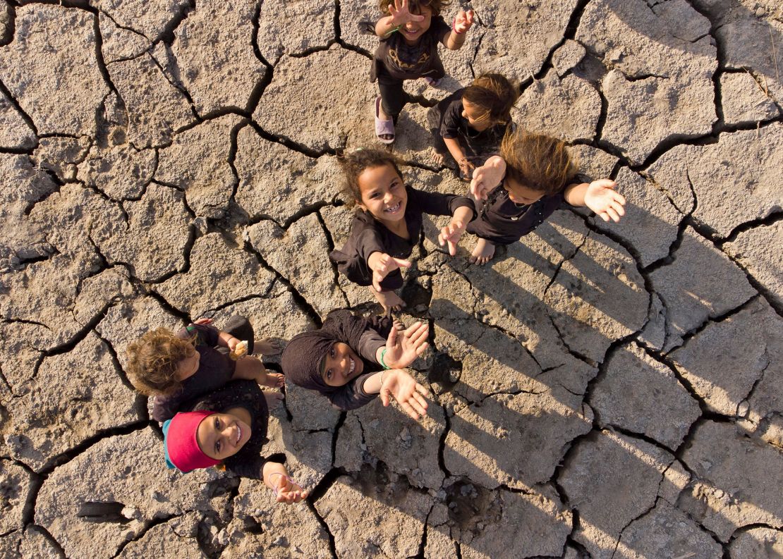 Children pose for an aerial photo on the dried-up bed of Iraq's receding southern marshes of Chibayish in Dhi Qar province on Tuesday.