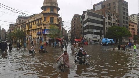 People walk through the flooded street after heavy monsoon rains in Karachi on July 25th.