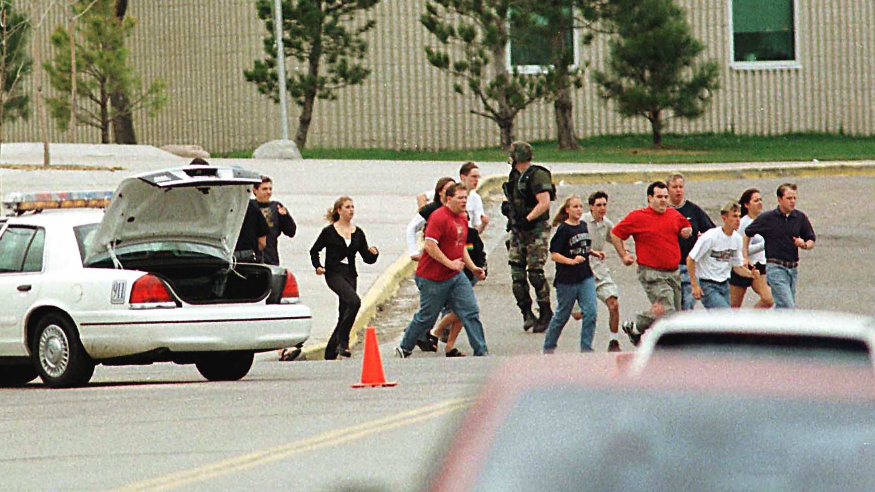 Columbine High School students run from the campus under police cover on April 20, 1999.