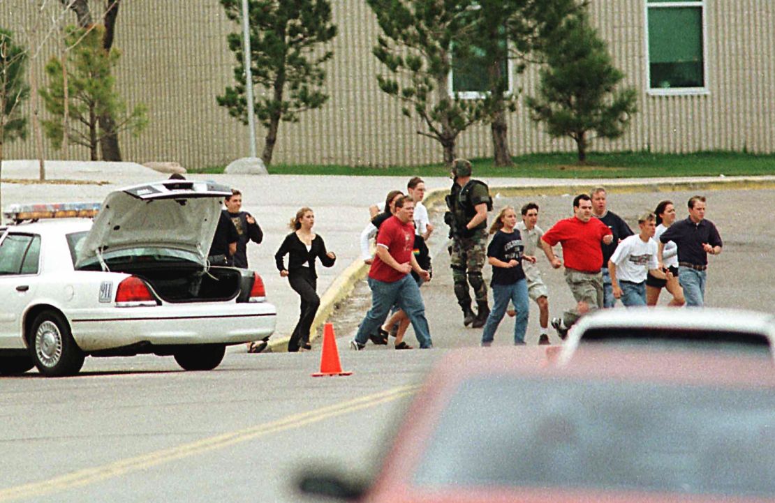 Columbine High School students run from the campus under police cover on April 20, 1999.