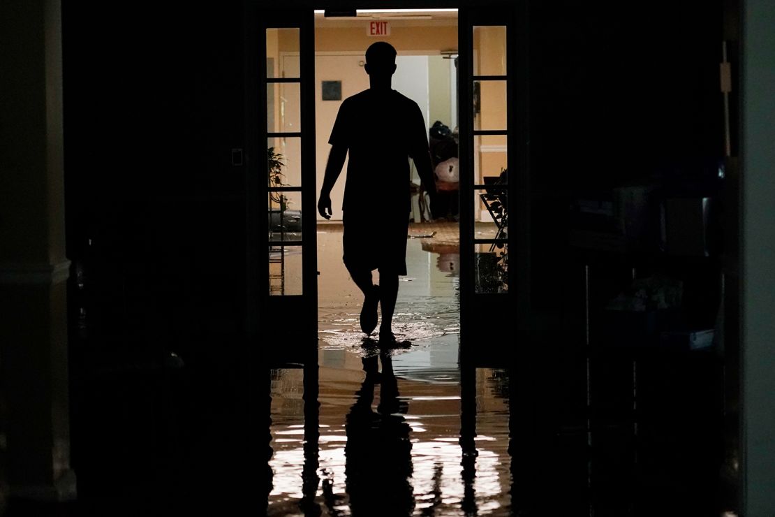 A relative walks through the Peach Tree Village nursing home to pick up family possessions after the facility was flooded on Wednesday.