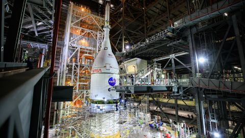 The Orion spacecraft for NASA's Artemis I mission, fully assembled with its launch abort system, is lifted above the Space Launch System rocket at the Kennedy Space Center in Florida on Oct. 20, 2021. 