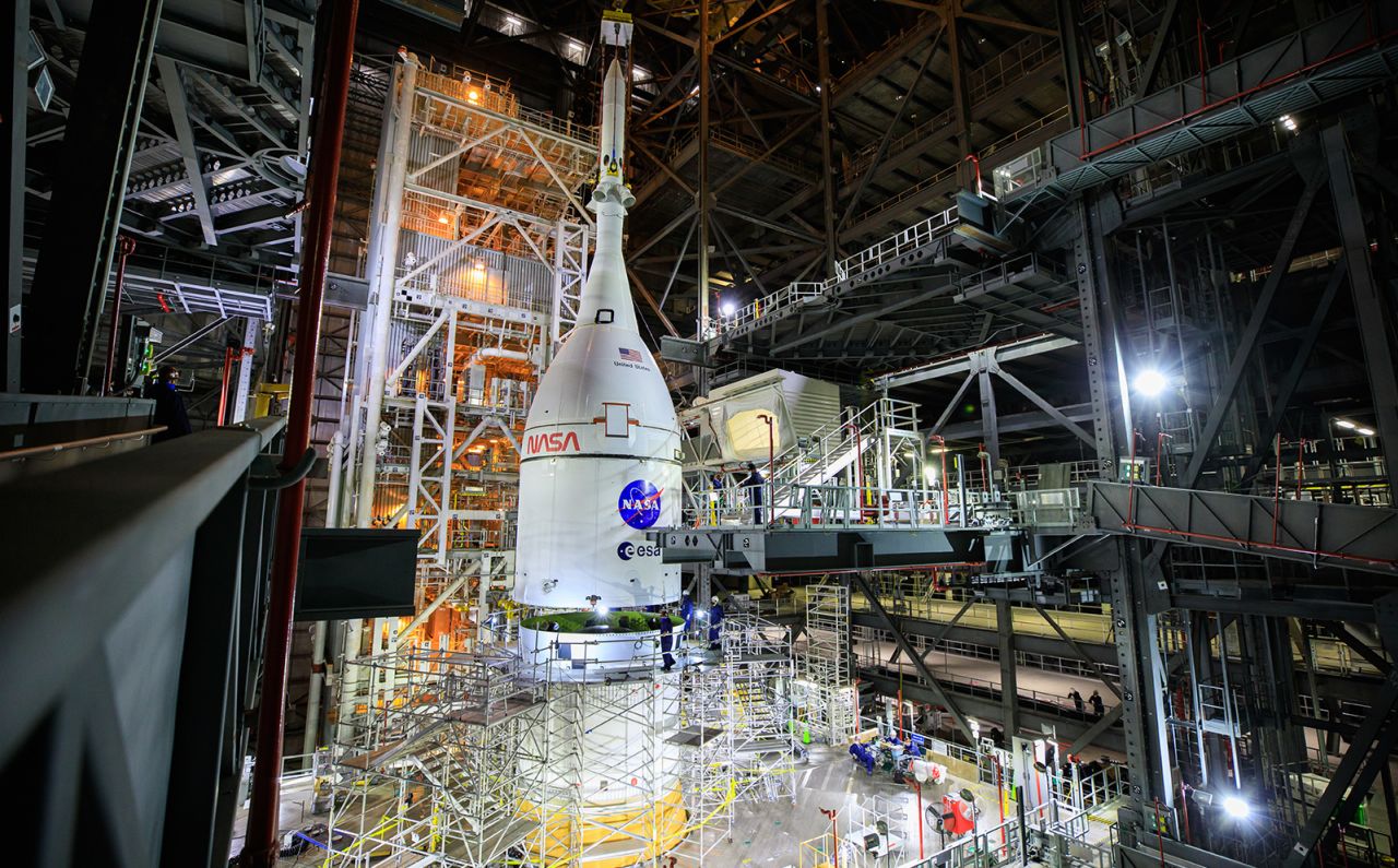 The fully assembled Orion spacecraft is lifted above the Space Launch System rocket at Kennedy Space Center on October 20, 2021. The stacking completed assembly for the Artemis I flight test. 
