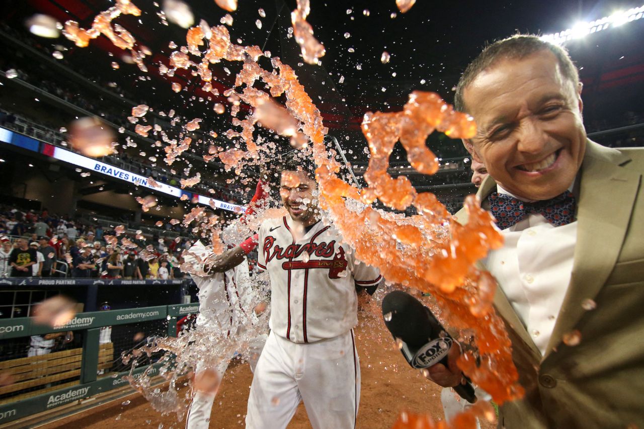 Fox reporter Ken Rosenthal, right, ducks out of the way as Atlanta Braves pinch hitter Travis D'Arnaud is doused with Gatorade after hitting a walk-off single against the Houston Astros in Atlanta on Saturday, August 20.