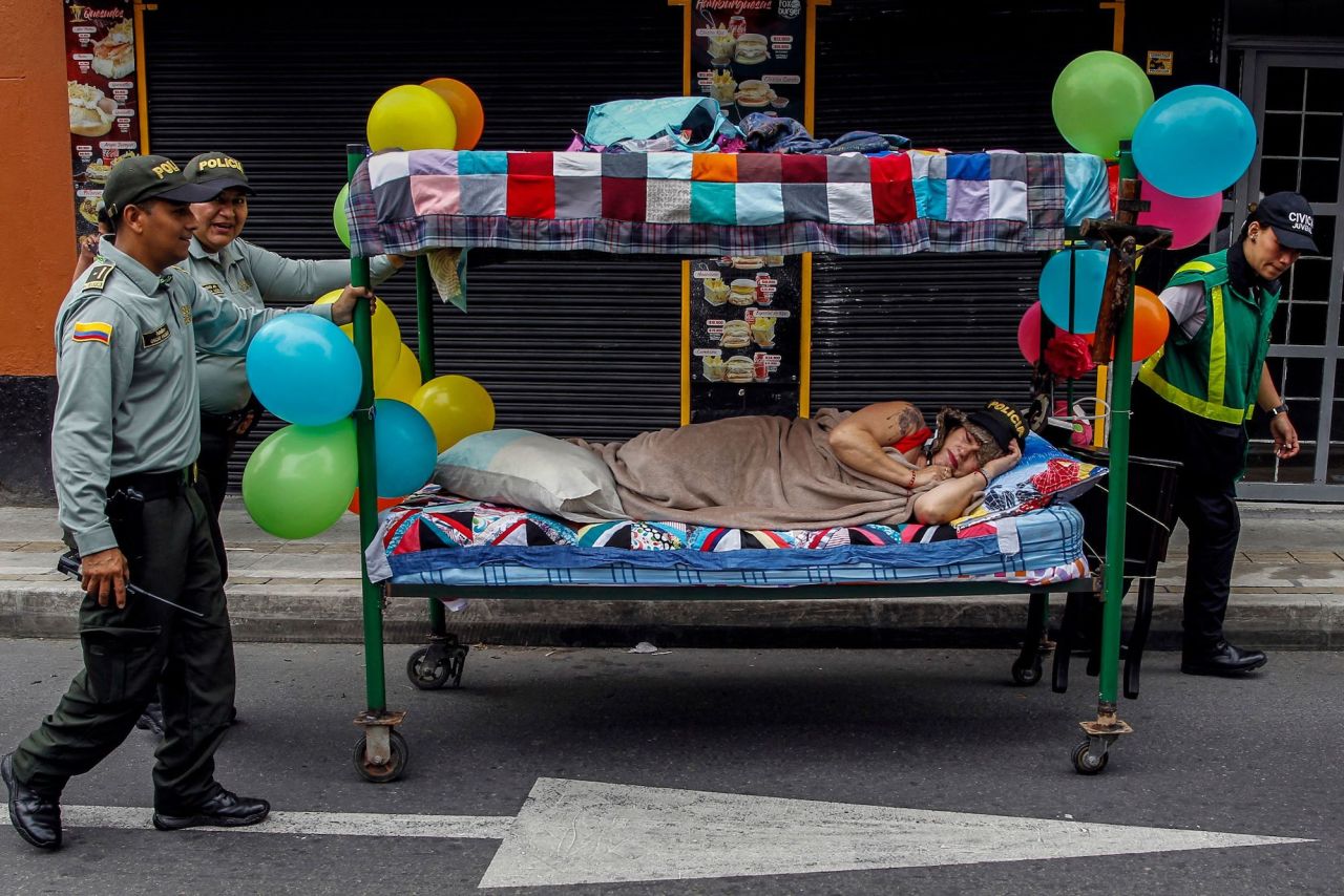Police officers push a bed during World Day of Laziness celebrations in Itagui, Colombia, on Sunday, August 21.