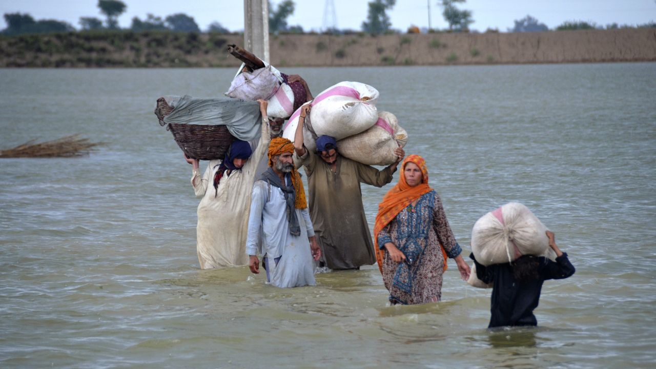 A displaced family wades through a flooded area in Jaffarabad, a district of Pakistan's southwestern Baluchistan province, on August 24.