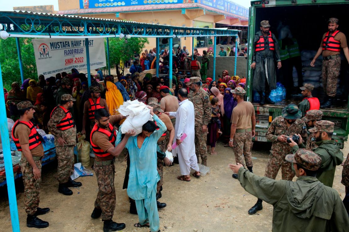 Army troops distribute food and supplies to displaced people at a relief camp in Jamshoro district, in southern Pakistan, on August 24.