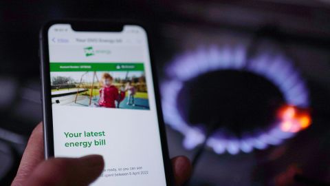 A general view of a household energy bill displayed on a mobile phone held next to a gas hob. Families across Great Britain will find out on Friday how tough energy bills will be this winter but they may have to wait to discover what the Government will do to help Picture date: Thursday August 25, 2022. (Photo by Yui Mok/PA Images via Getty Images)