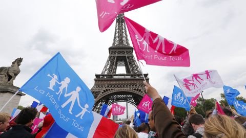 Supporters of the anti-gay marriage movement "La Manif pour tous" (Demonstration for all) wave flags in front of the Eiffel Tower during a mass protest on May 26, 2013 in Paris against a gay marriage law.