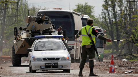 Buses carrying service members of Ukrainian forces who have surrendered after weeks holed up at Azovstal steel works drive away under escort of the pro-Russian military in Mariupol, Ukraine May 17, 2022.