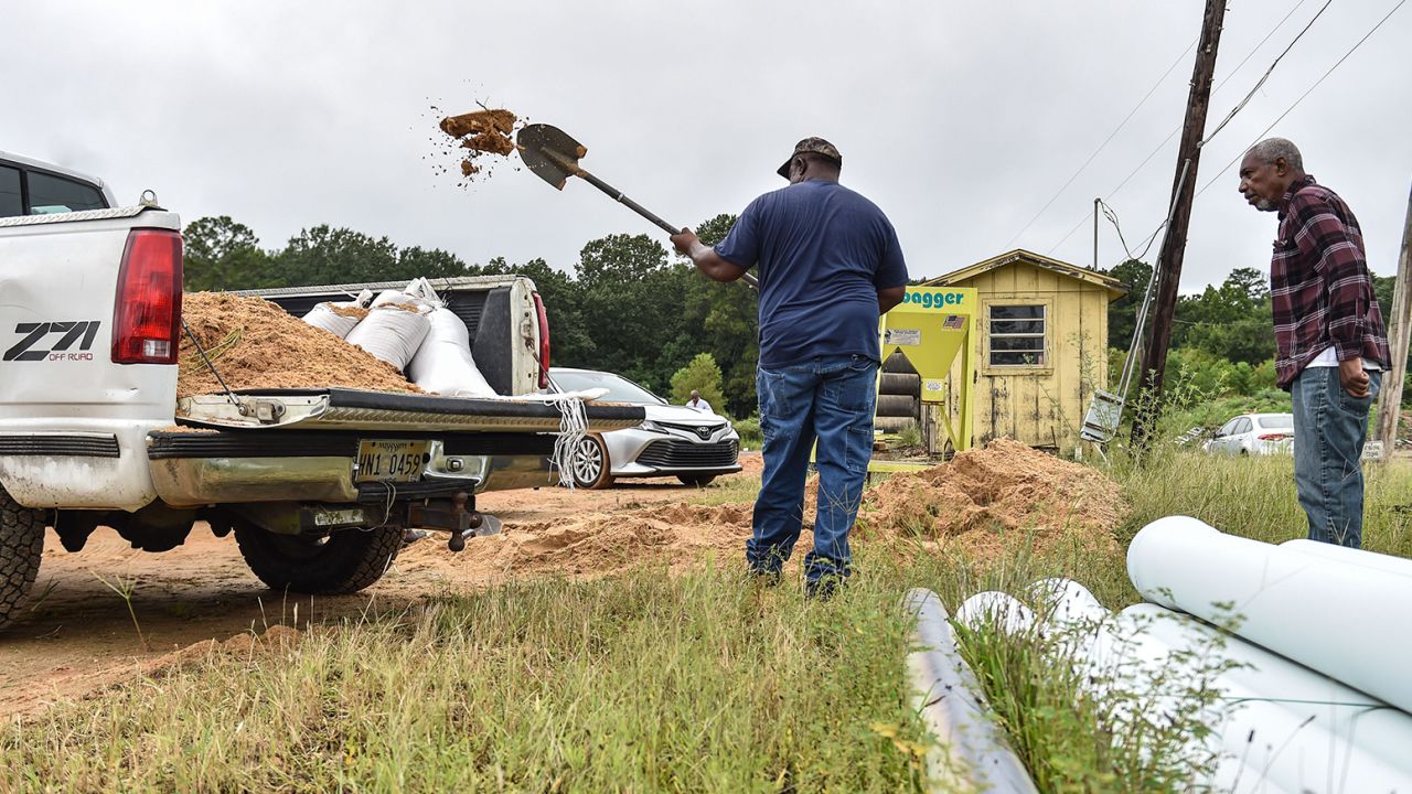 Sidney Cary, left, shoveled his own sand straight into his truck to assist with flooding at City of Jackson Public Works.