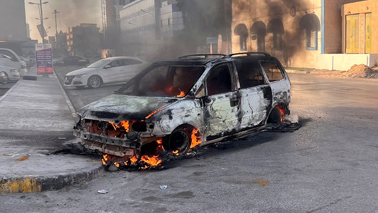 A car burns in the street during clashes in Tripoli, Libya August  27, 2022. 