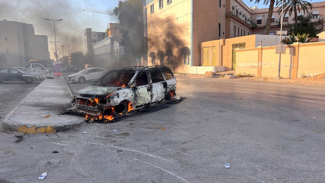 A car burns in the street during clashes in Tripoli, Libya August  27, 2022. 