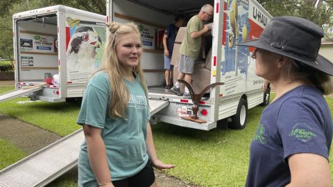Medical student Emily Davis, left, speaks with her landlord Suzannah Thames Friday as workers move furniture, appliances and other belongings out of a home Davis and her husband are renting in a flood-prone area of Jackson, Mississippi.