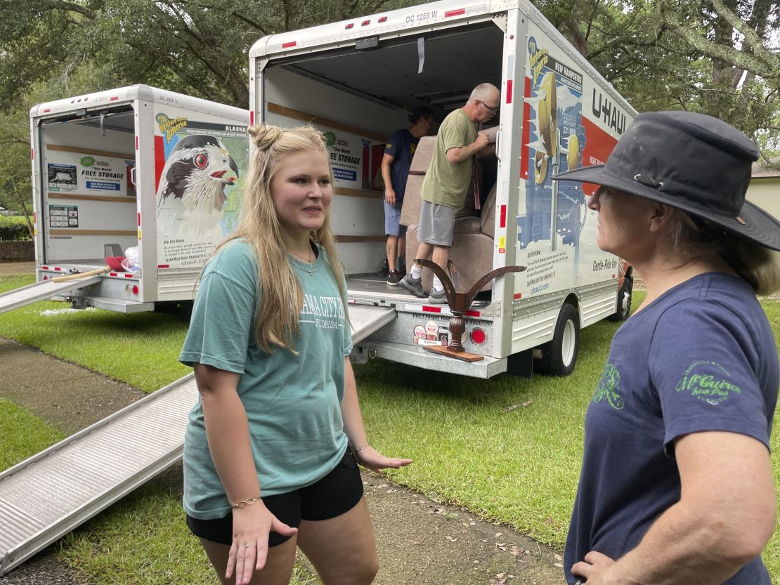 Medical student Emily Davis, left, speaks with her landlord Suzannah Thames Friday as workers move furniture, appliances and other belongings out of a home Davis and her husband are renting in a flood-prone area of Jackson, Mississippi.