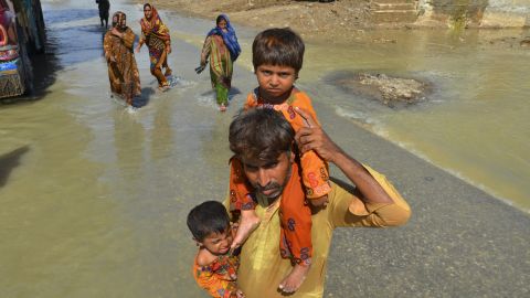 Vysídlená osoba v sobotu nese své dcery ze svého povodněmi poškozeného domu v Džafarabádu, předměstí pákistánské jihozápadní provincie Balúčistán. 