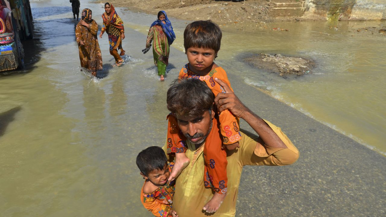 A displaced man carries his daughters from his flood-hit home in Jaffarabad, a district of Pakistan's southwestern Baluchistan province on Saturday. 