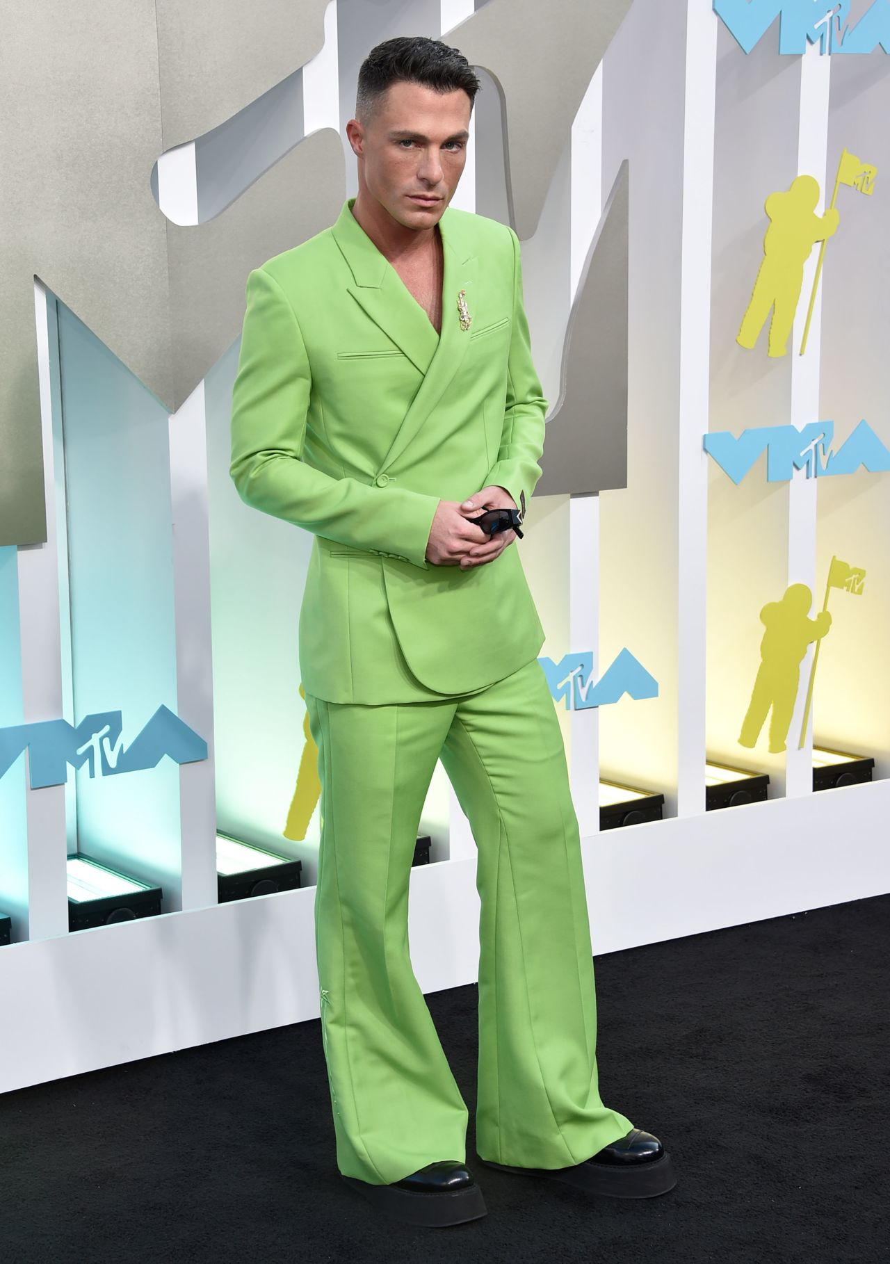 Actor Colton Haynes was impossible to miss in an acid green flared suit by Dior, featuring a wrapped blazer, diamond brooch and platform shoes.