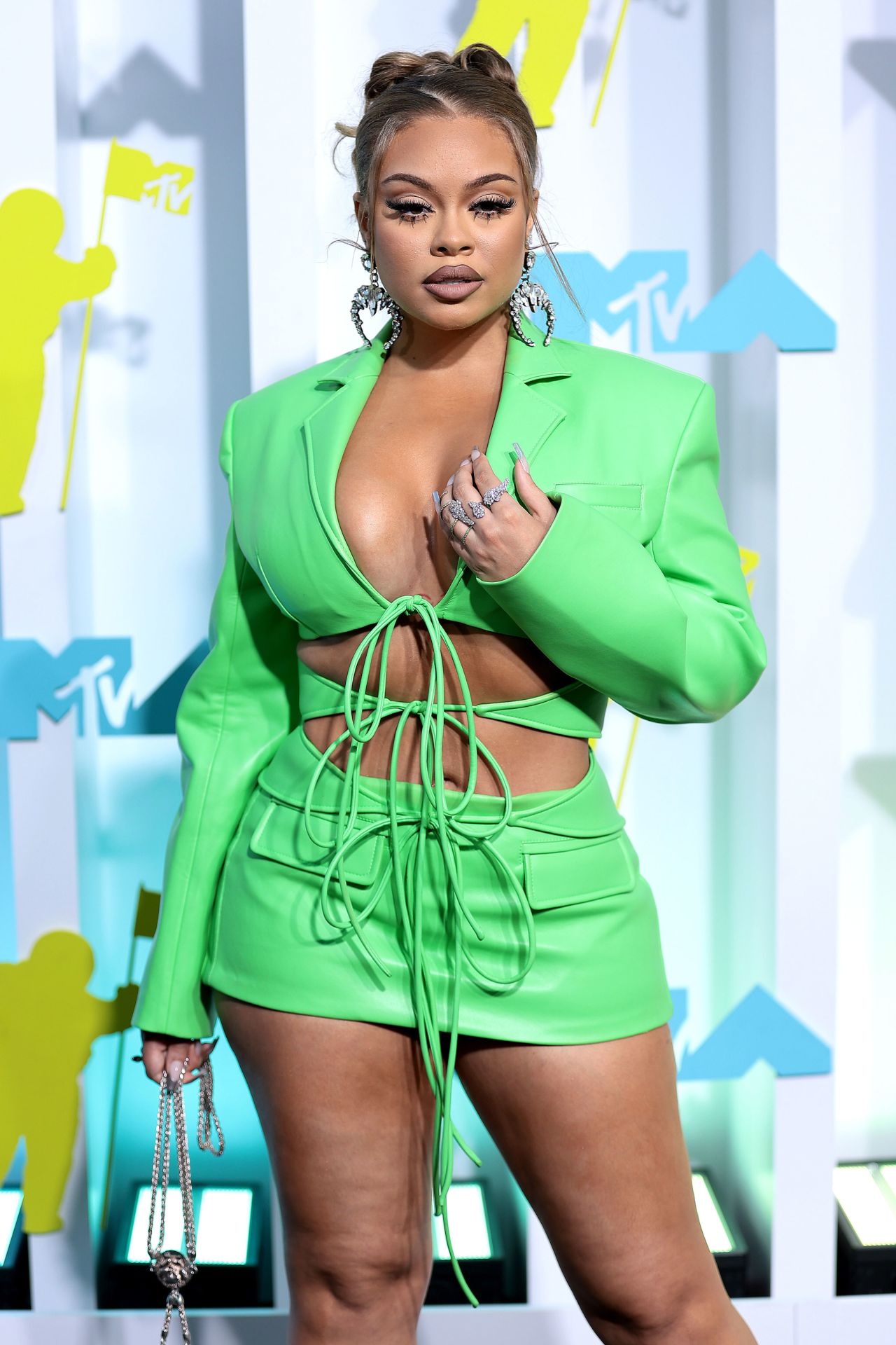 Bright greens popular on the VMAs carpet, with rapper Latto wearing a lace-up mini dress in a neon shade.