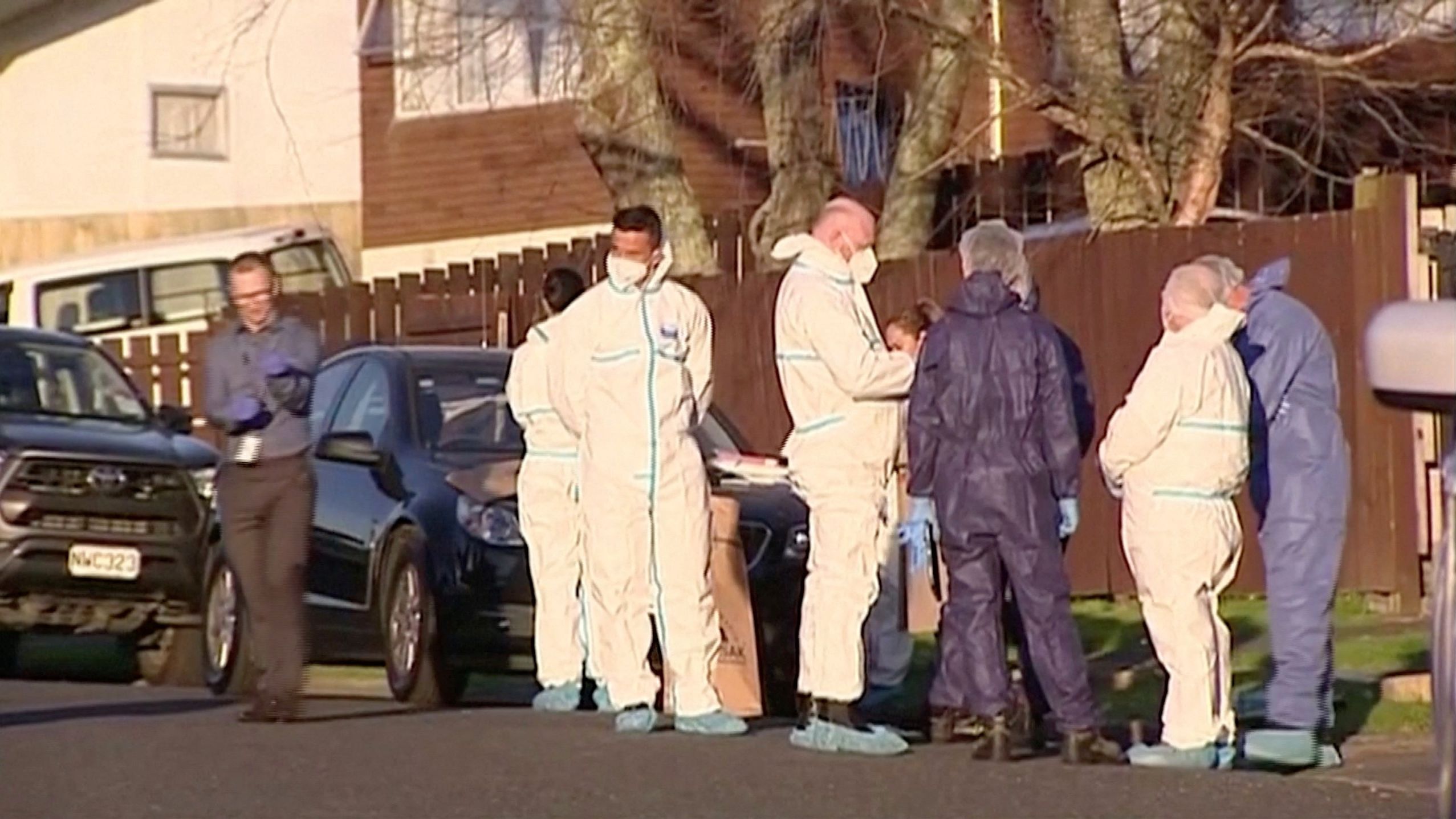 Police and forensic investigators gather at the scene where suitcases with the remains of two children were found in Auckland, New Zealand.