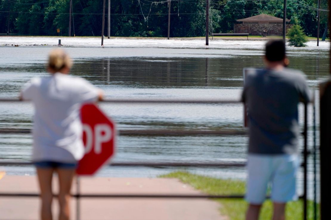 People peer over the security gate Sunday on the lane to the flooded Madison County, Mississippi, side of the boat launch at the Ross Barnett Reservoir Spillway Recreation Area.