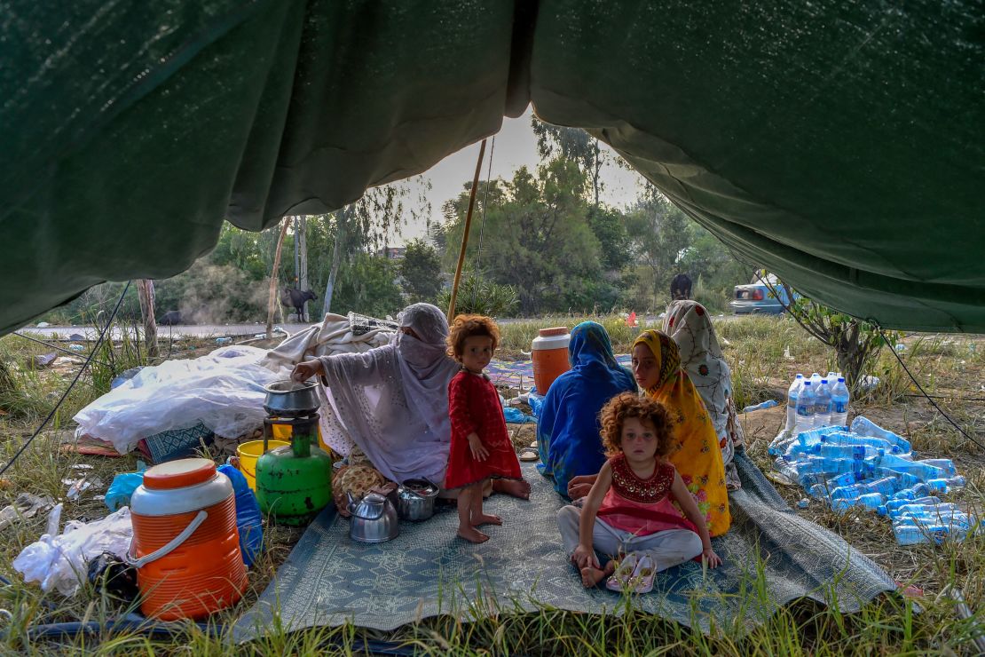 Displaced people prepare for breakfast in their tents at a makeshift camp after fleeing from their flood-hit homes following heavy monsoon rains in Charsadda district of Khyber Pakhtunkhwa on August 29, 2022.
