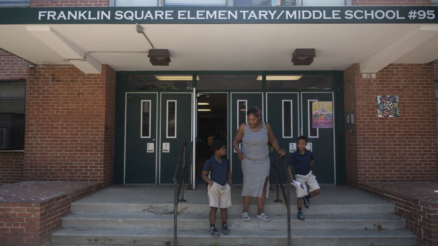 A Baltimore parent picks up her children at Franklin Square Elementary/Middle School in May, when high temperatures also led to an early release. 