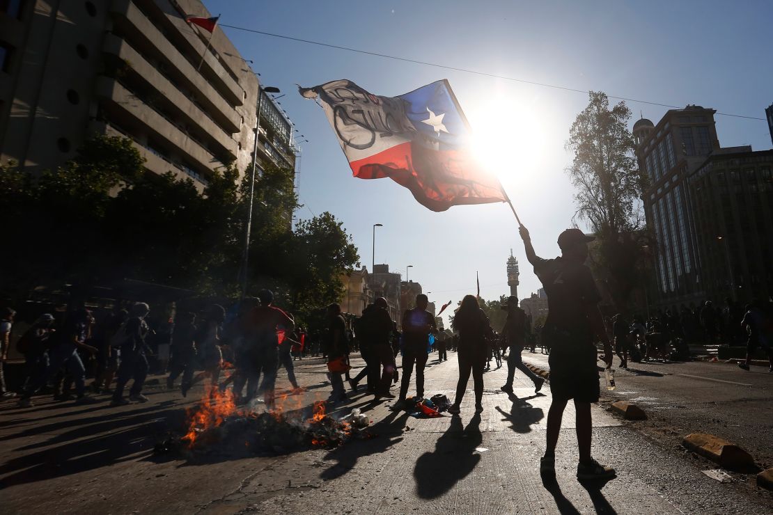 A demonstrator waves the Chilean flag during a November 2020 protest against then President Sebastian Pinera in Santiago.
