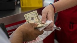 A customer pays cash for a purchase at a Tractor Supply Co. store in Merced, California, US, on Tuesday, July 19, 2022. 
