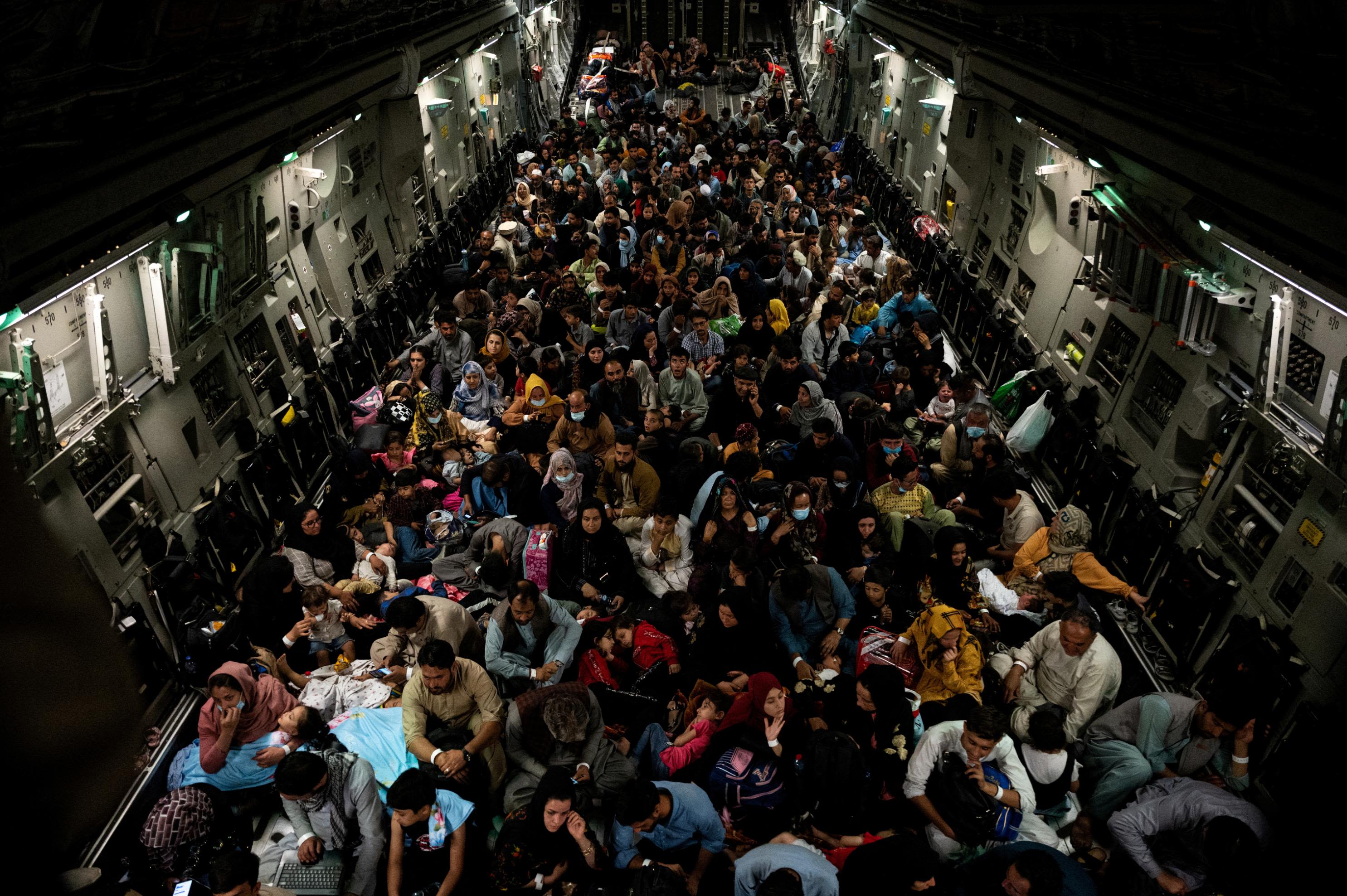 People sit inside a military aircraft during an evacuation from Kabul in August 2021.