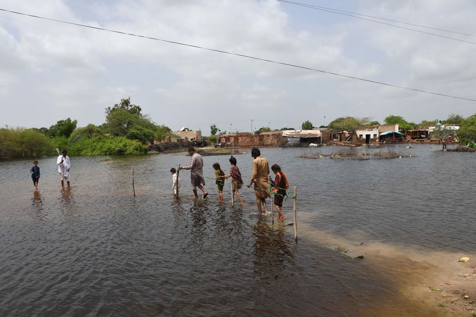 People wade through floodwaters in Pakistan's Mirpur Khas district on August 28.