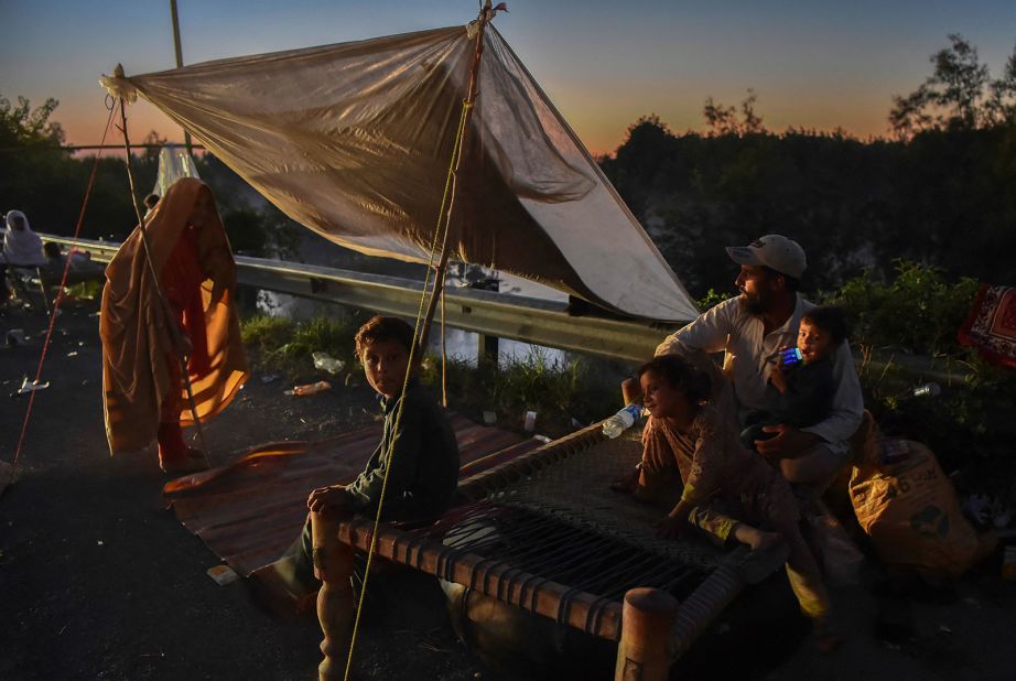 Displaced people take refuge along a highway after fleeing from their flood-hit homes in Pakistan's Charsadda district on August 28.