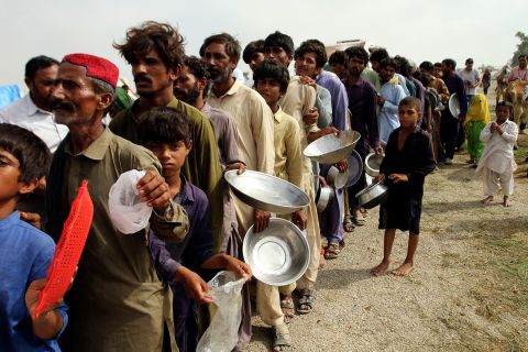Flood-affected people stand in a long line for food distributed by Pakistani Army troops in Rajanpur on August 27.