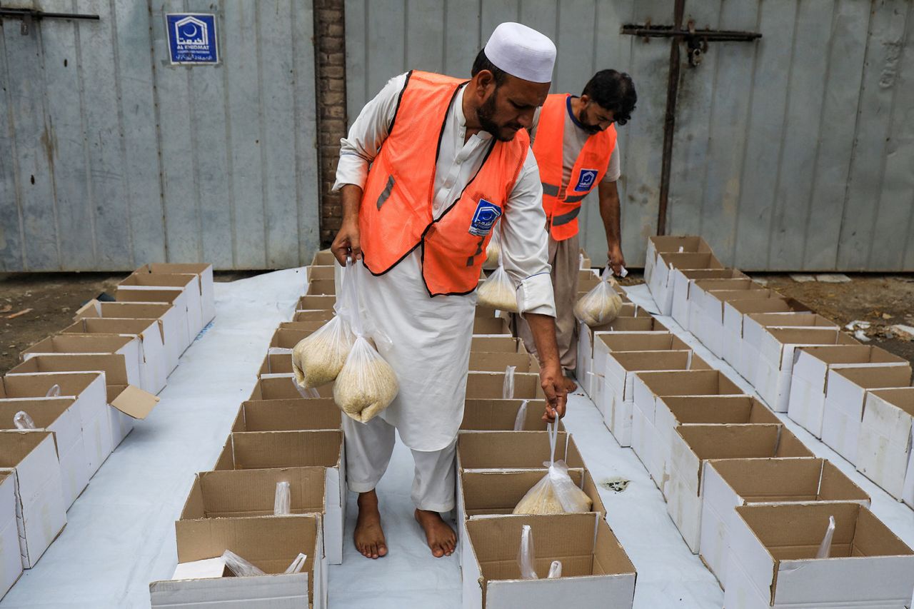 Volunteers prepare food boxes to distribute to flood victims in Peshawar on August 26.