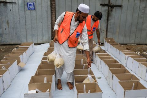 Volunteers prepare food boxes to distribute among flood victims in Peshawar on Friday, August 26.