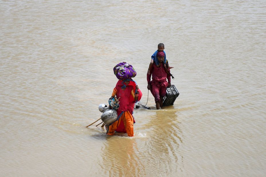 A family carries their belongings through floodwaters in Jamshoro, Pakistan, on August 26.