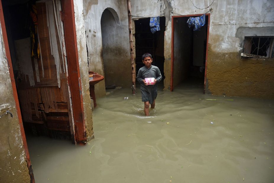 A boy wades through his flooded house in Karachi on July 26.