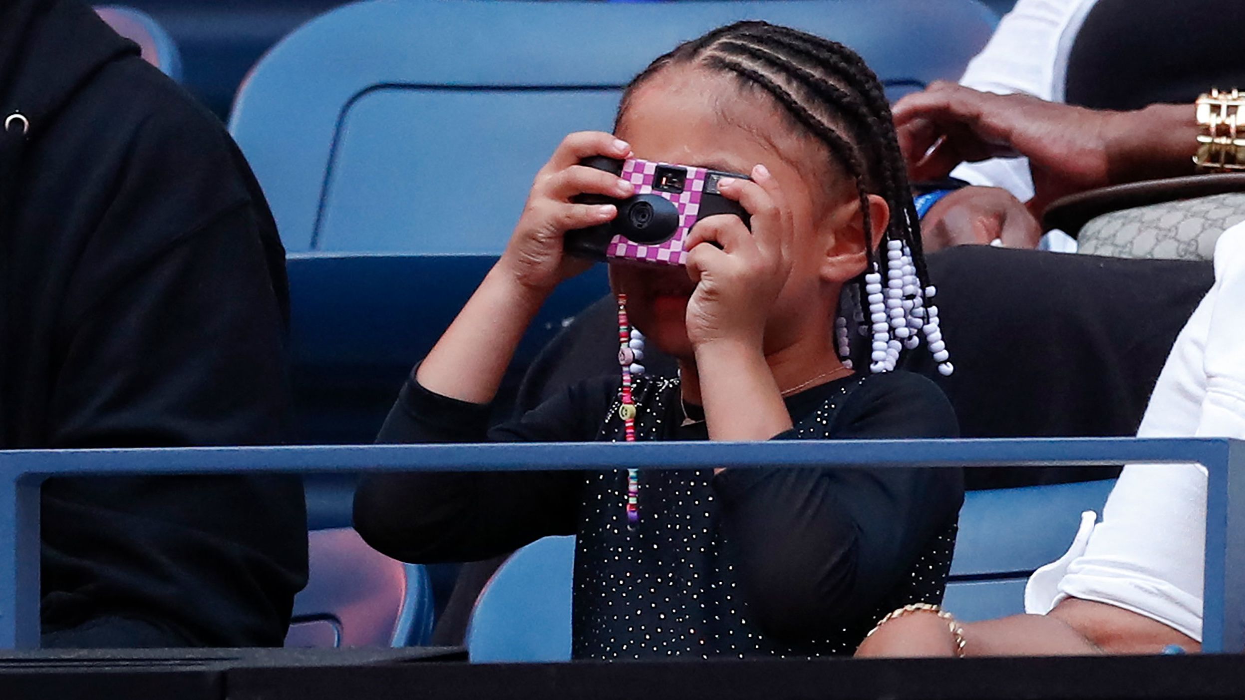 Williams' daughter, Olympia, takes a picture before her mom's match on Monday.