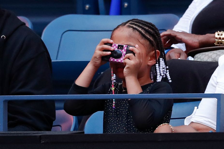 Williams' daughter, Olympia, takes a picture before her mom's match on Monday.