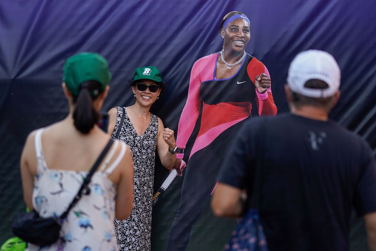 Fans pose for photos next to a life-sized image of Williams on Monday.