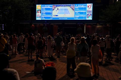 Fans outside the stadium watch the Williams match on a video screen Monday.