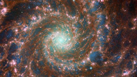M74 shines at its brightest in this combined optical/mid-infrared image, featuring data from both the Hubble Space Telescope and the James Webb Space Telescope. 
