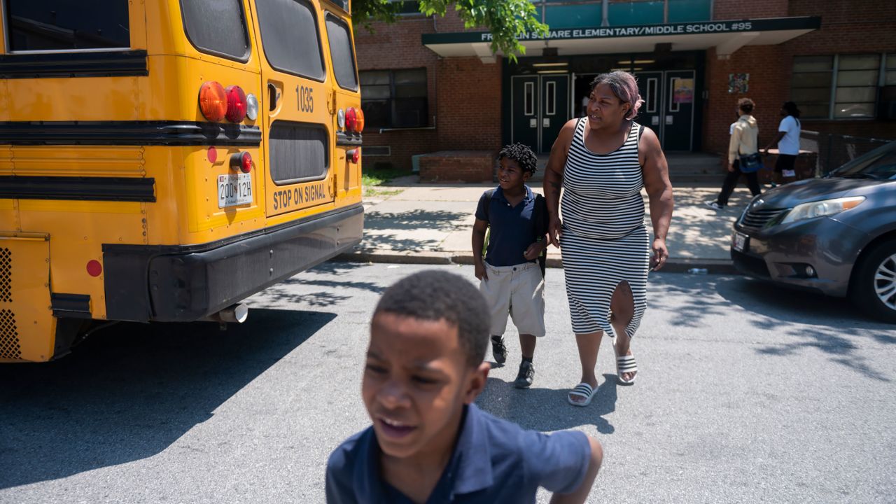 A Baltimore parent picks up her children at Franklin Square Elementary/Middle School in May, when high temperatures also led to an early release.