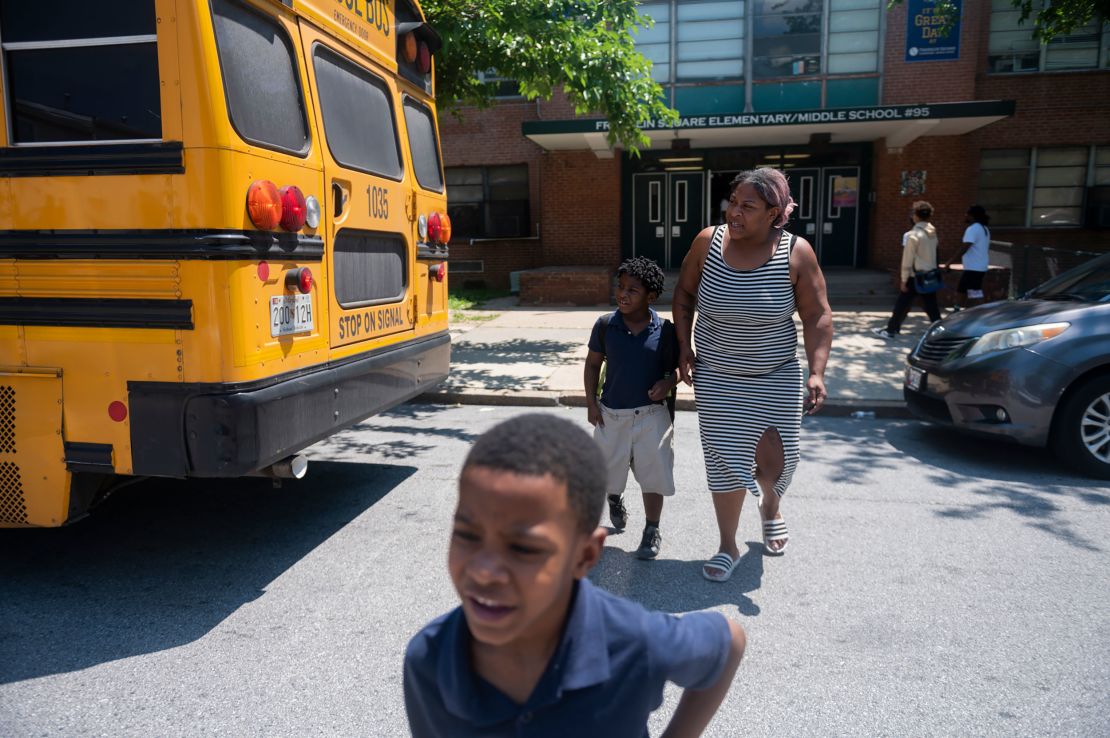 A Baltimore parent picks up her children at Franklin Square Elementary/Middle School in May, when high temperatures also led to an early release.