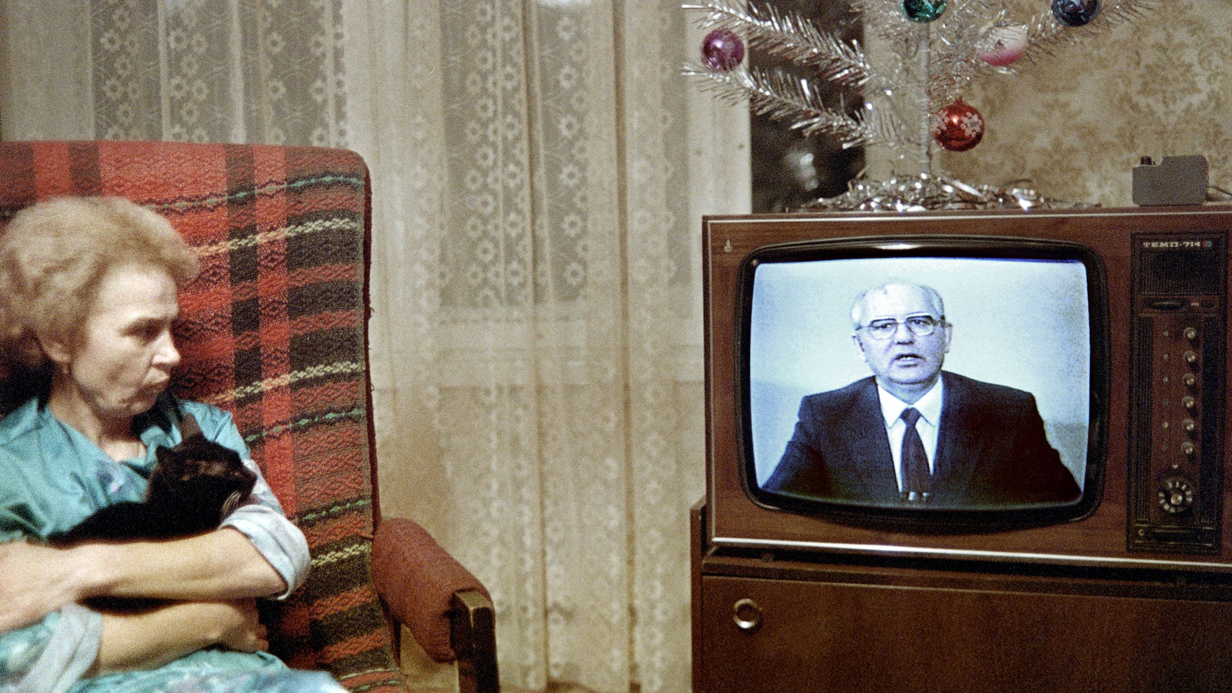 A Moscow woman and her cat watch Gorbachev's New Year message in December 1988.