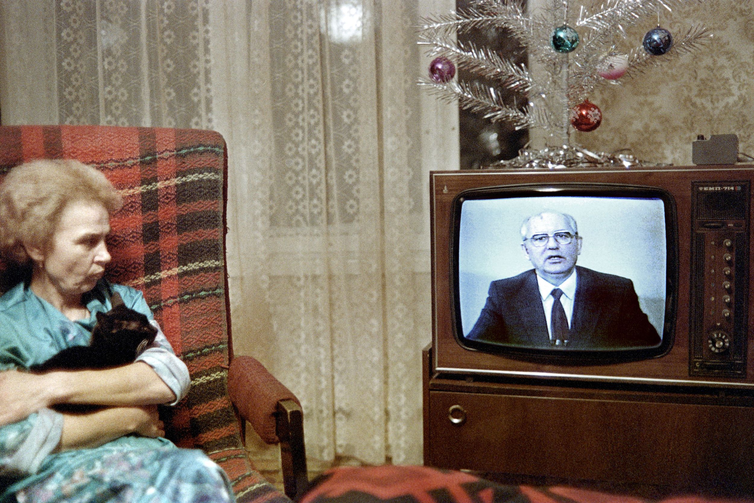 A Moscow woman and her cat watch Gorbachev's New Year message in December 1988.